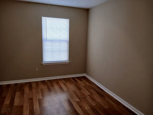a view of a room with wooden floor and a window