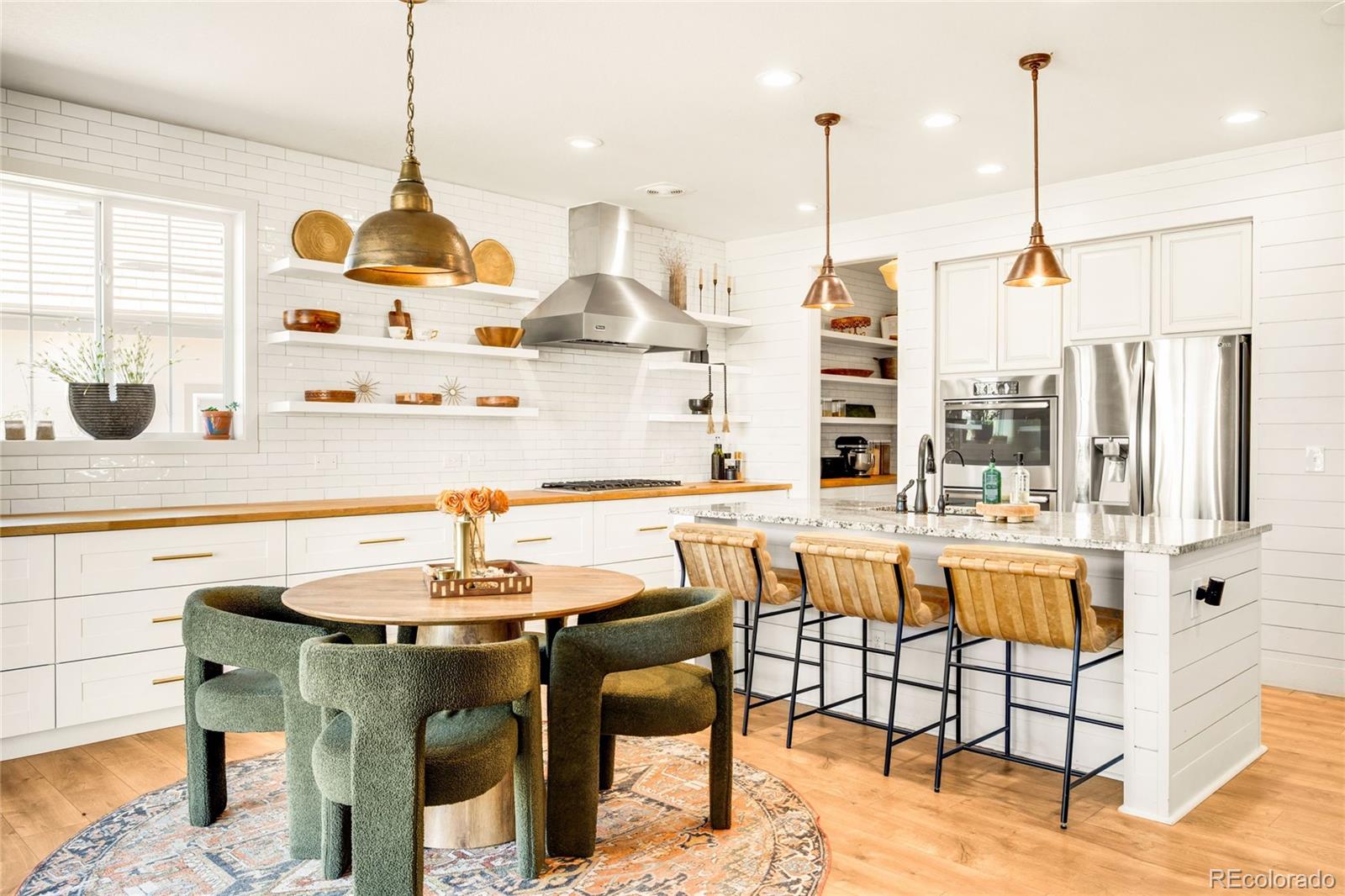 683 Tiger Lily Way Highlands Ranch, CO 80126 - Photo 13 of 50 a kitchen with a table chairs and white cabinets