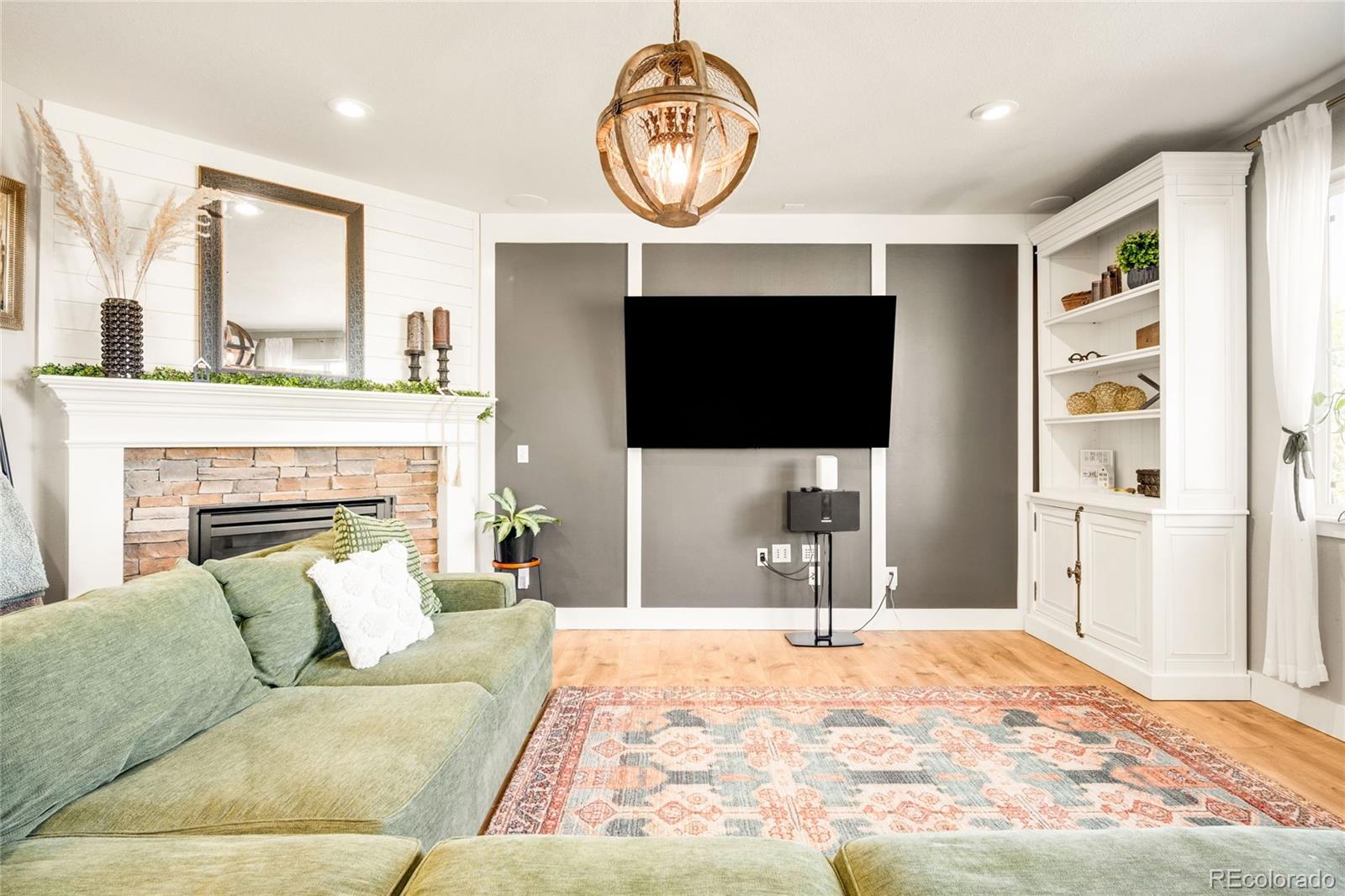 683 Tiger Lily Way Highlands Ranch, CO 80126 - Photo 15 of 50 a living room with furniture a fireplace and a flat screen tv