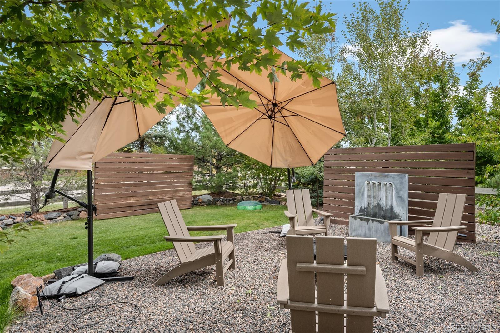 683 Tiger Lily Way Highlands Ranch, CO 80126 - Photo 45 of 50 a view of a backyard with table and chairs under an umbrella