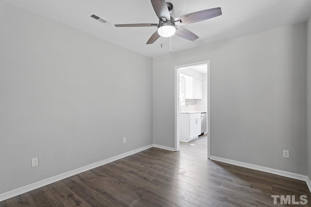 1404 Kent Road Raleigh, NC 27606 - Photo 14 of 28 a view of an empty room with a window and wooden floor