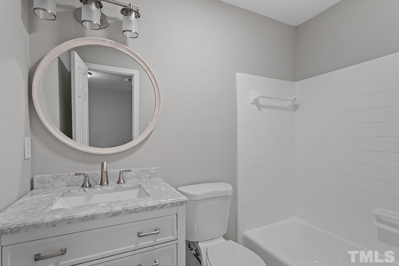 1404 Kent Road Raleigh, NC 27606 - Photo 20 of 28 a bathroom with a granite countertop sink a mirror and toilet