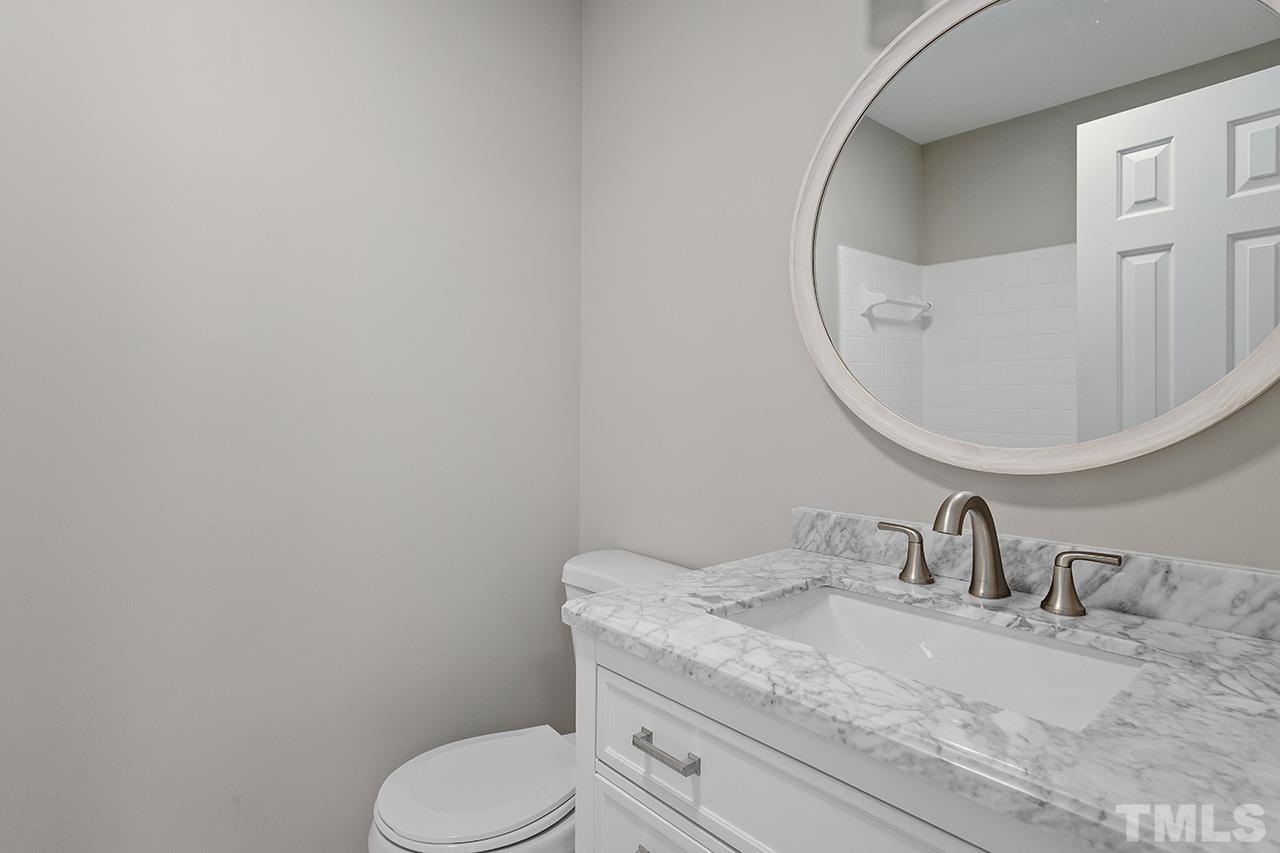 1404 Kent Road Raleigh, NC 27606 - Photo 25 of 28 a bathroom with a granite countertop sink and a mirror