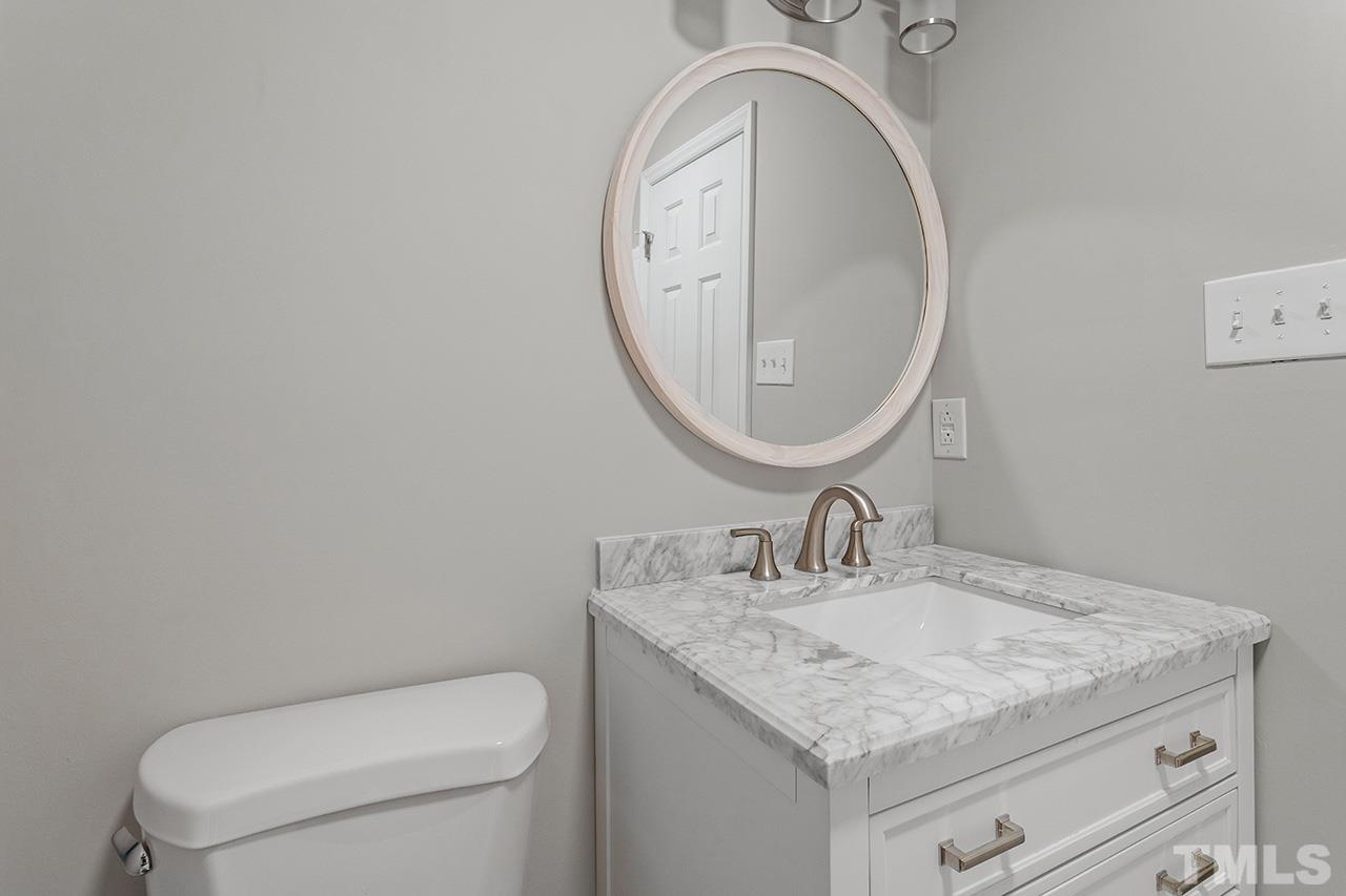 1404 Kent Road Raleigh, NC 27606 - Photo 26 of 28 a bathroom with a granite countertop toilet sink and mirror