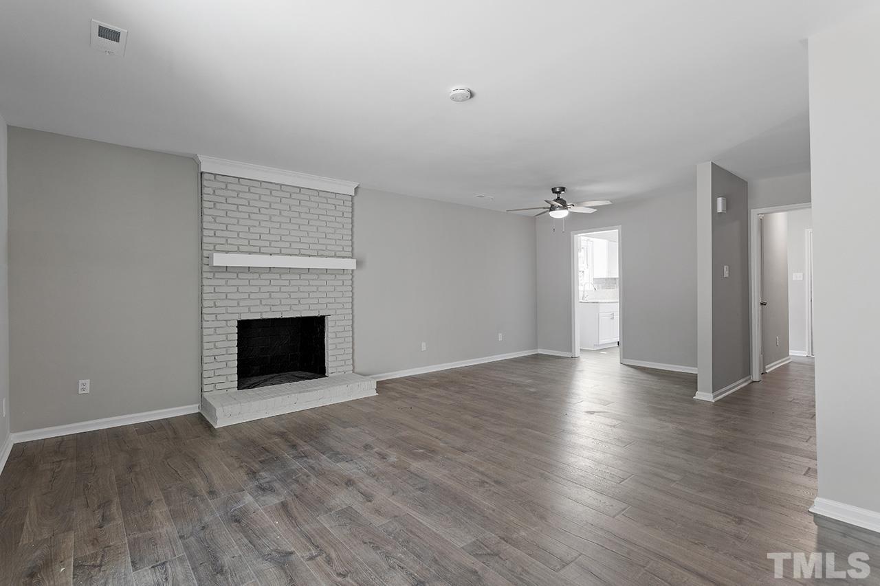 1404 Kent Road Raleigh, NC 27606 - Photo 4 of 28 a view of a livingroom with wooden floor and a fireplace