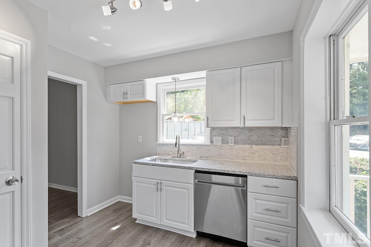 1404 Kent Road Raleigh, NC 27606 - Photo 10 of 28 a kitchen with granite countertop white cabinets and white appliances
