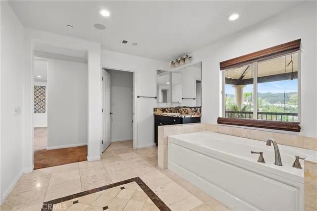 a bathroom with a tub sink and mirror