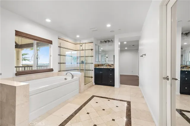 a large bathroom with a tub double vanity sink and a mirror