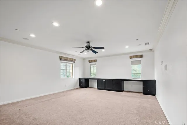 an empty room with windows and cabinet