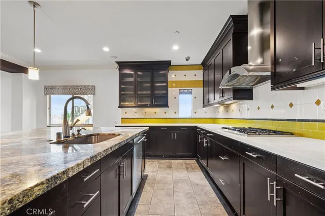 a kitchen with stainless steel appliances granite countertop a sink a stove and a wooden floors