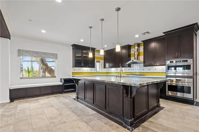 a large kitchen with stainless steel appliances granite countertop a stove and a sink