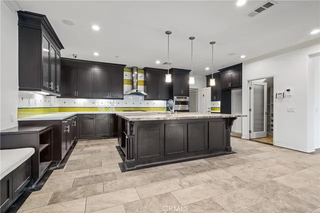 a kitchen with kitchen island stainless steel appliances a sink stove and refrigerator
