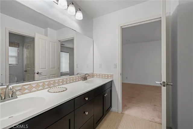 a bathroom with a double vanity sink and a mirror