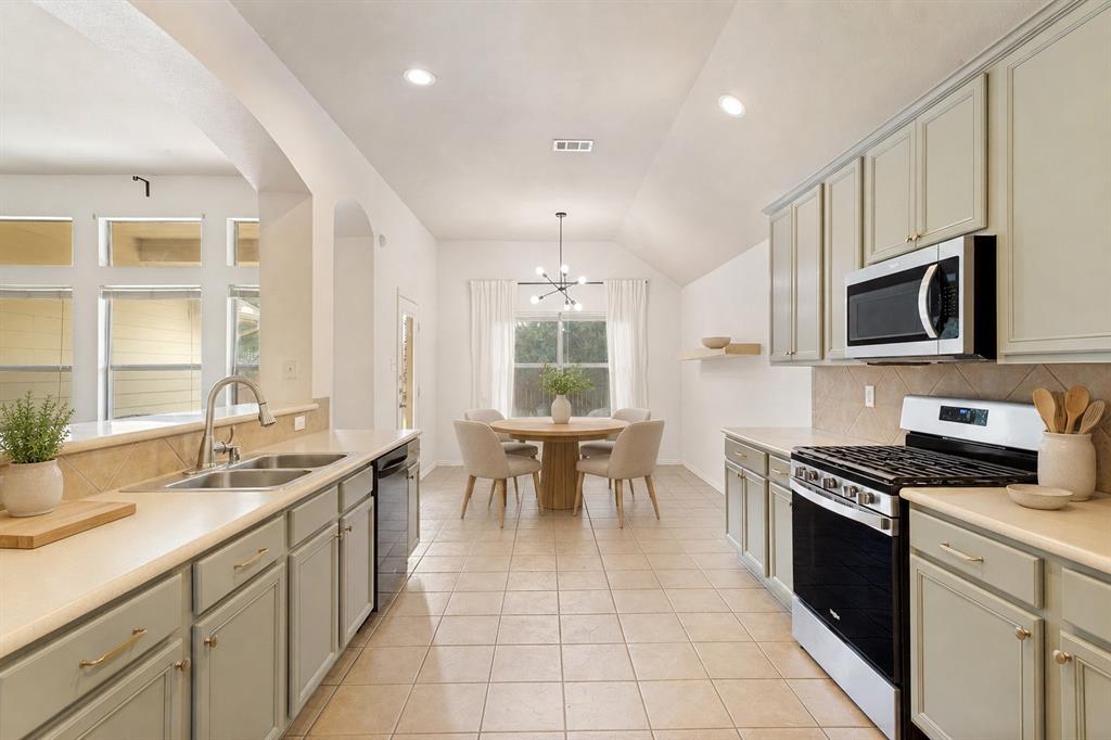 1316 Mountain Air Trail Fort Worth, TX 76131 - Photo 5 of 23 Spacious kitchen featuring light-toned cabinetry, stainless steel appliances, tile flooring, and a tile backsplash