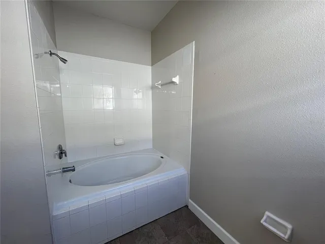 a white bath tub sitting next to a shower