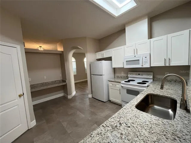 a kitchen with refrigerator a stove a sink and a stove