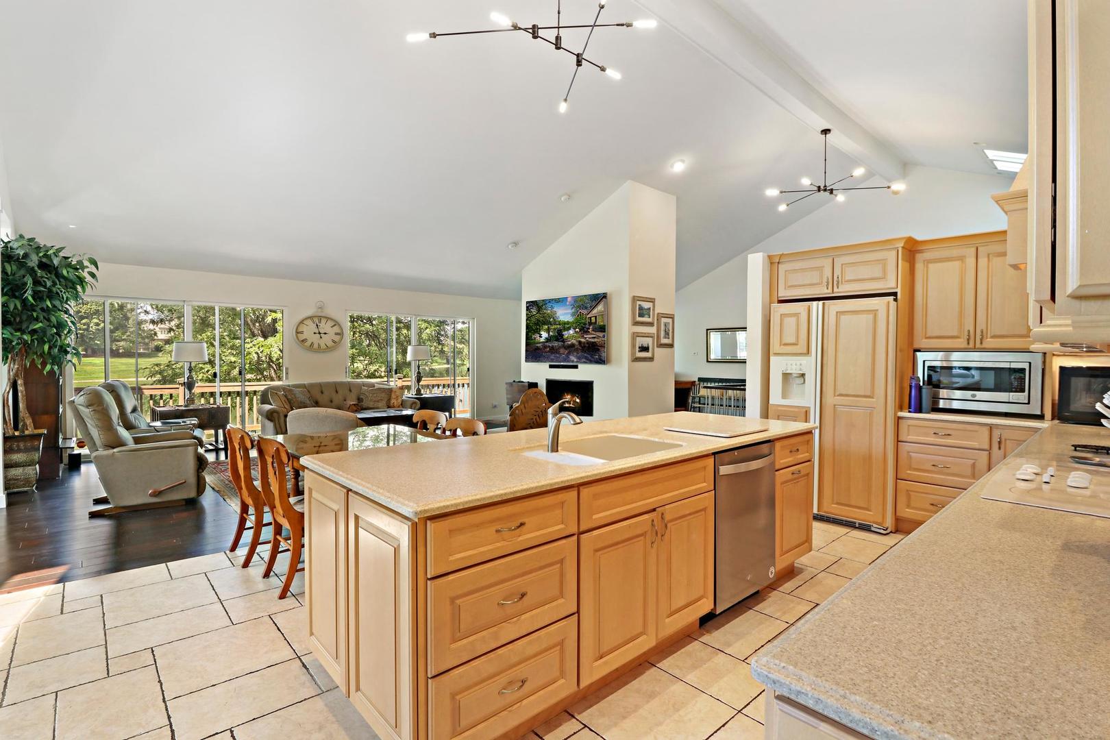 30 West Mundhank Road South Barrington, IL 60010 - Photo 20 of 45 a large kitchen with kitchen island a stove a sink a refrigerator and a dining table with wooden floor