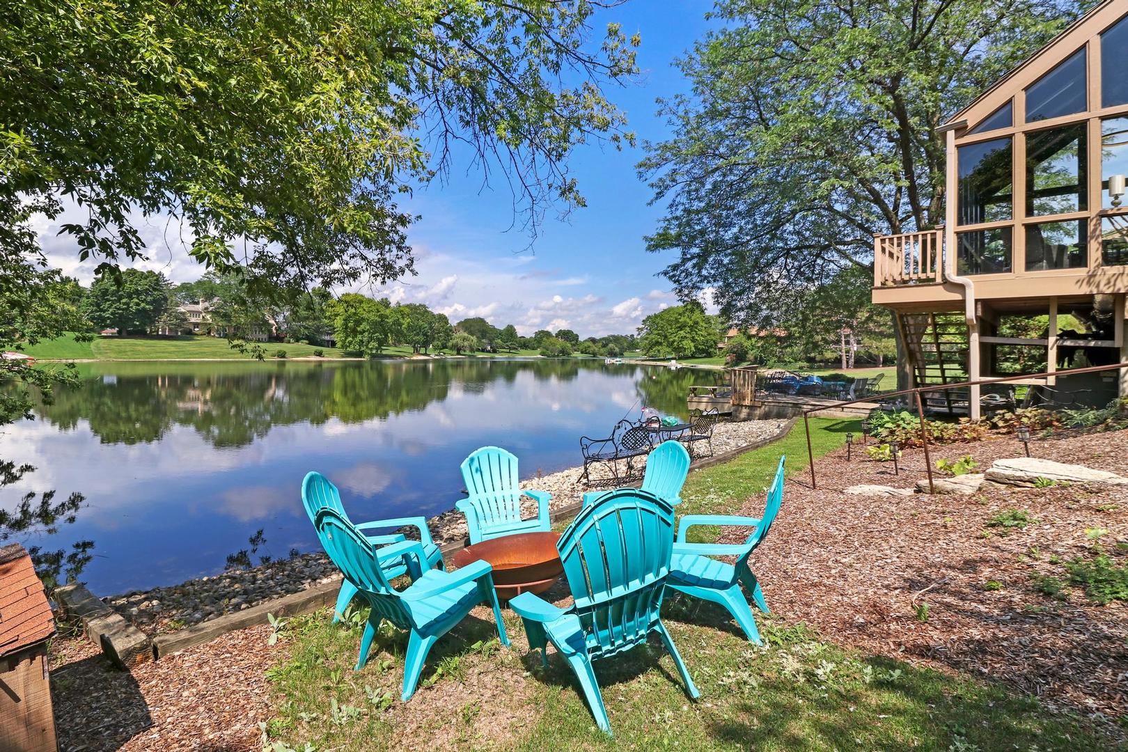 30 West Mundhank Road South Barrington, IL 60010 - Photo 8 of 45 a view of a lake with table and chairs under an umbrella