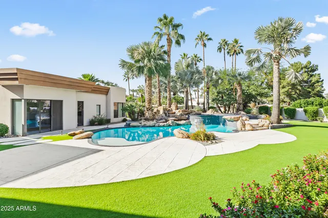 a view of a house with swimming pool and a small yard