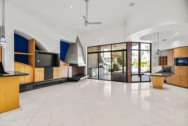 a view of an empty room with furniture and a large window