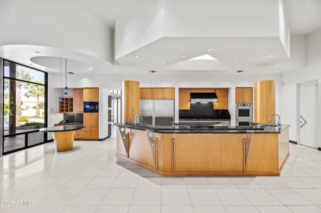 a large living room with stainless steel appliances granite countertop a sink and cabinets
