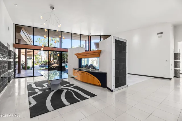 a view of an empty room with a window and a kitchen