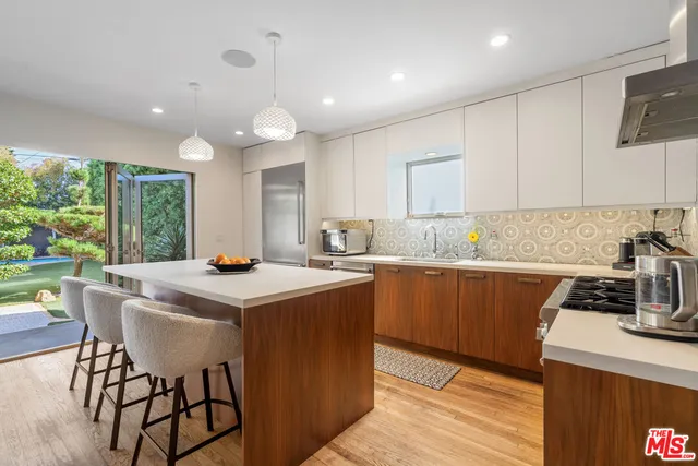 a kitchen with a sink a stove a refrigerator cabinets and wooden floor