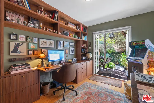a work place with a large window and a book shelf