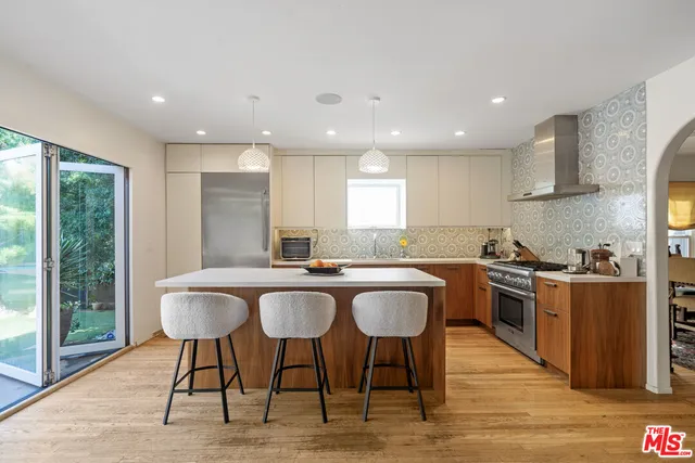 a kitchen with stainless steel appliances granite countertop table chairs sink and wooden floor
