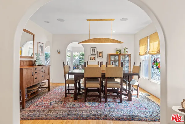 a view of a dining room and livingroom with furniture wooden floor and a rug