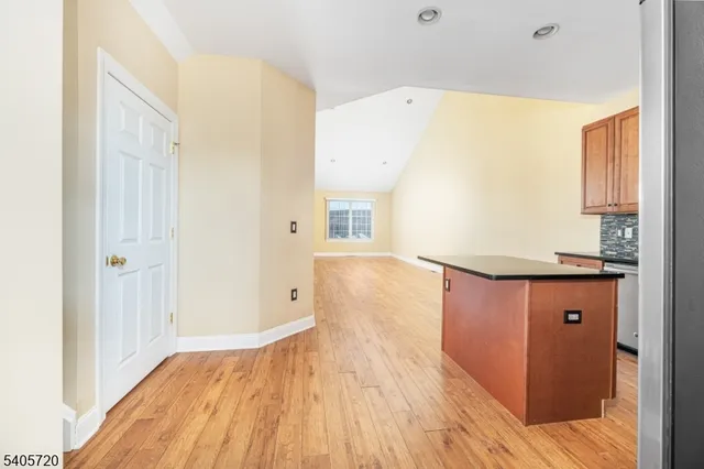 a kitchen with stainless steel appliances granite countertop a refrigerator a stove and a sink with wooden cabinets