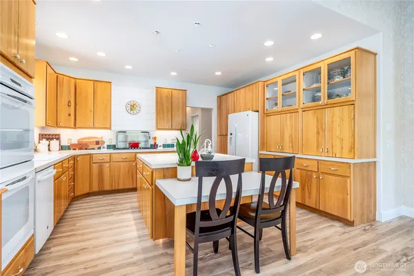 a kitchen with a table chairs sink and cabinets