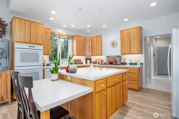 a kitchen with kitchen island granite countertop a sink stove and cabinets