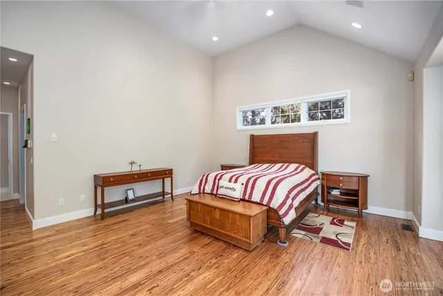 a bedroom with a bed and wooden floor