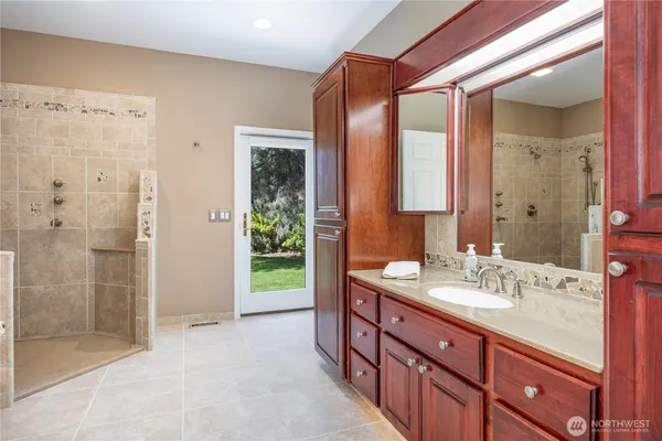 a spacious bathroom with a shower sink and mirror