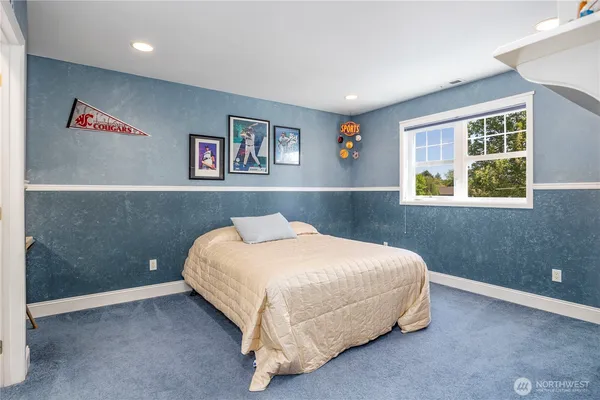 a bed sitting in a bedroom next to a window