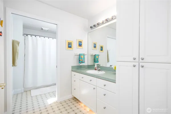 a bathroom with a granite countertop sink a mirror and shower