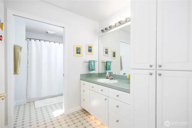 a bathroom with a granite countertop sink a mirror and shower