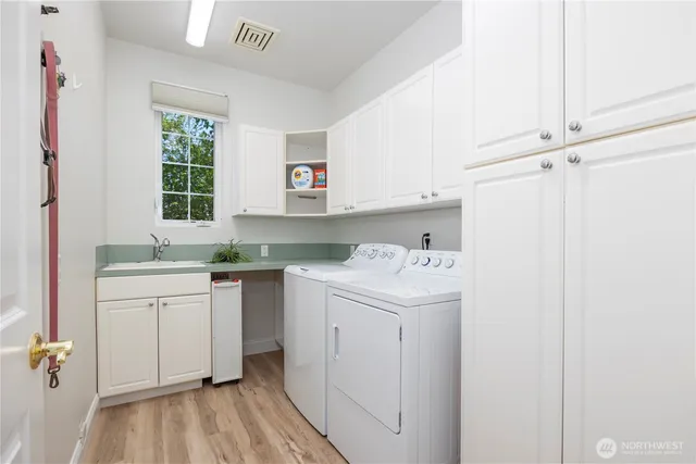 a utility room with cabinets washer and dryer