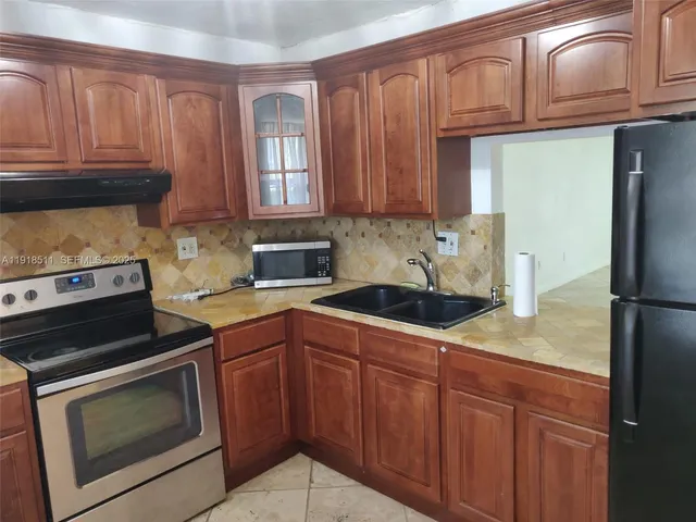 a kitchen with stainless steel appliances granite countertop a stove microwave and refrigerator