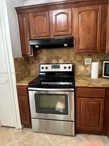 a stove top oven sitting inside of a kitchen