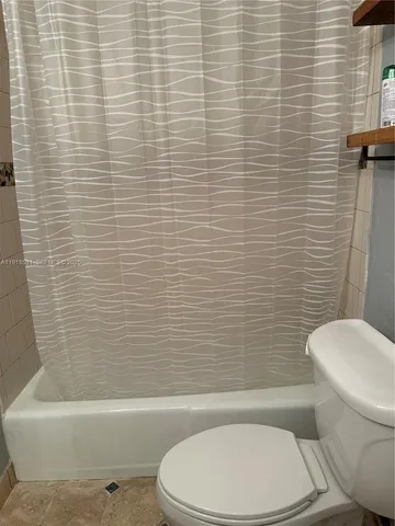 a white toilet and tub sitting next to a bathroom sink