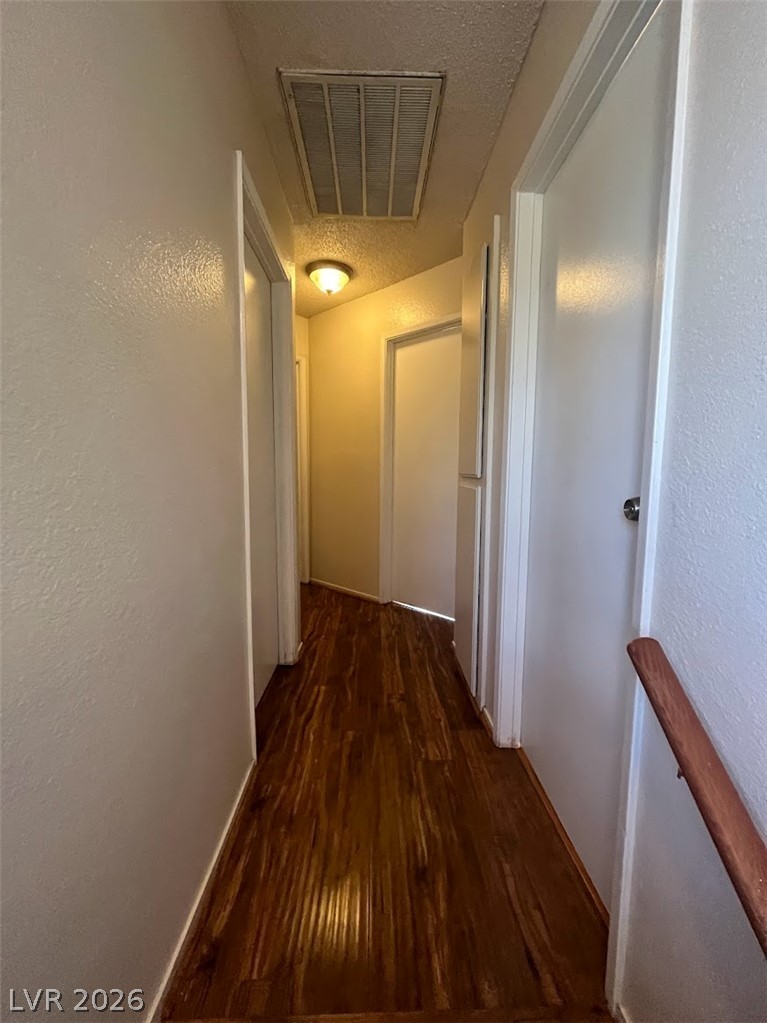 914 Scarlet Ridge Drive Las Vegas, NV 89128 - Photo 16 of 25 A well-lit corridor with rich wood flooring leads to several interior doorways.