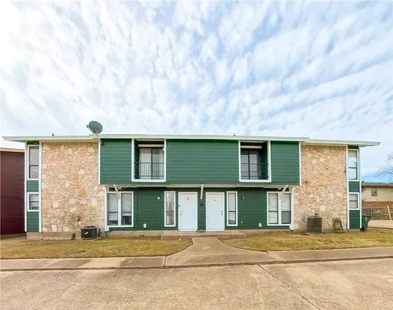 a front view of a house with a basket ball court and garage