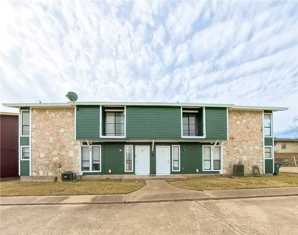 a front view of a house with a basket ball court and garage