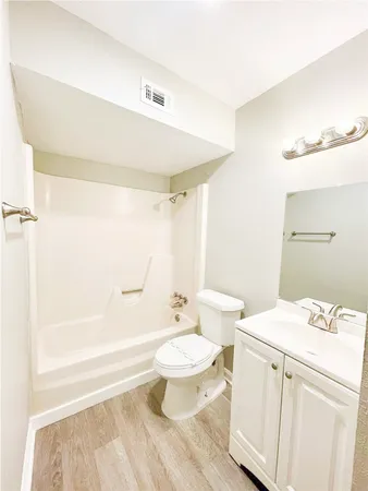 a bathroom with a white toilet sitting next to a bathroom sink and a shower