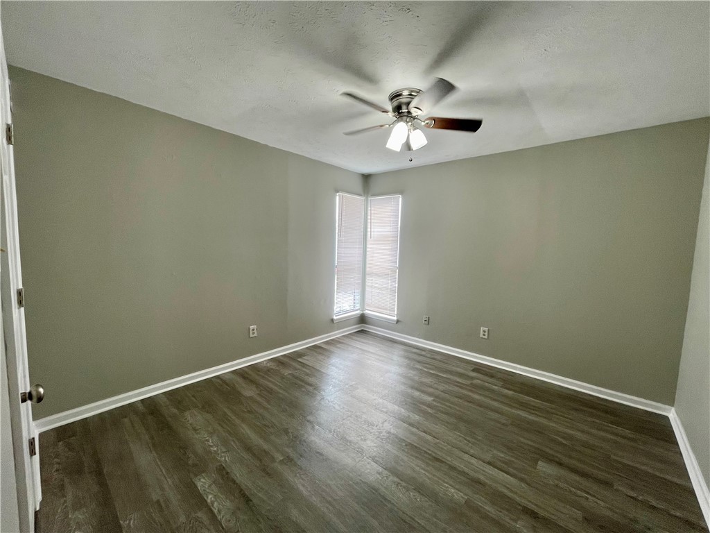 2406 Toro Lane, Unit B Bryan, TX 77807 - Photo 9 of 13 an empty room with wooden floor fan and windows