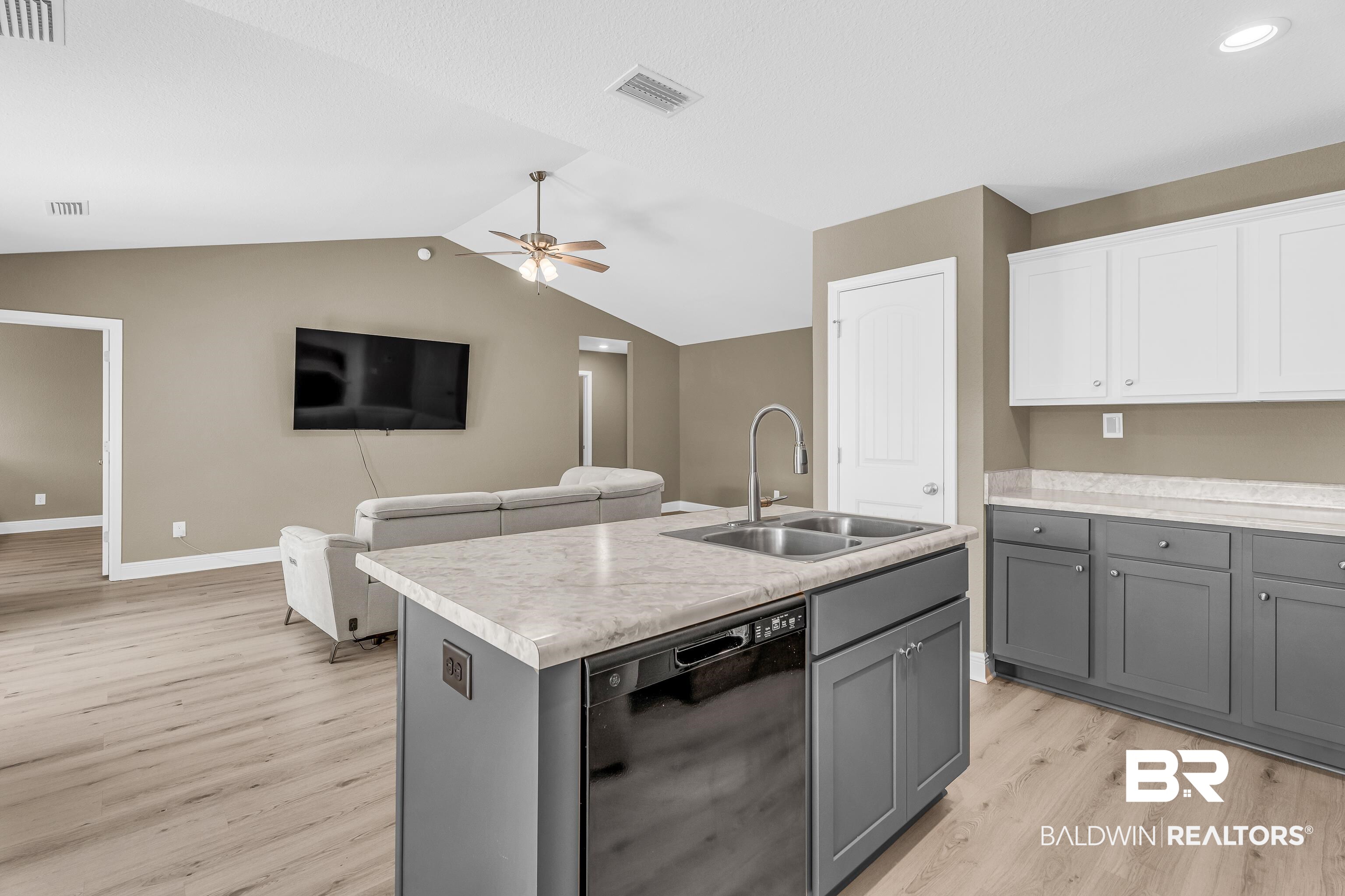 9206 Greenleaf Drive Daphne, AL 36527 - Photo 32 of 32 Kitchen featuring gray cabinets, light countertops, black dishwasher, open floor plan, and light wood finished floors