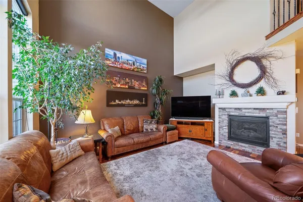 a living room with furniture a flat screen tv and a fireplace