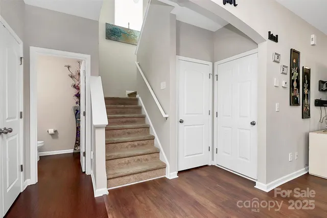 a view of a hallway with wooden floor and entryway